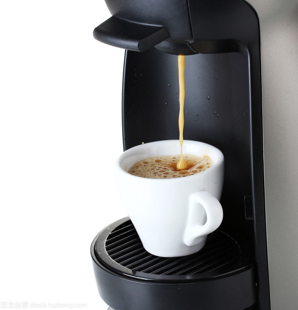 澆上白色隔離的杯中的咖啡的咖啡機(jī)